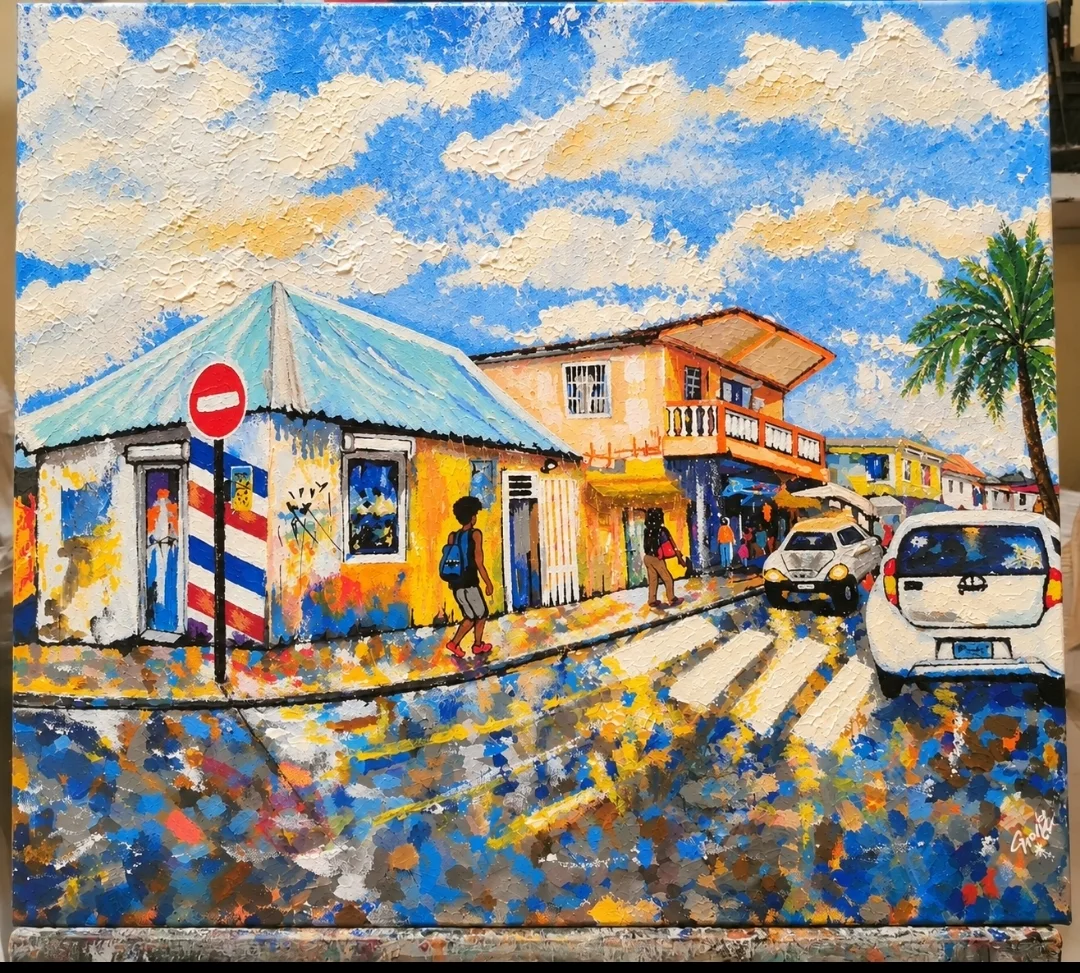 Carrefour de Marigot avec enseigne de barbier et voitures
