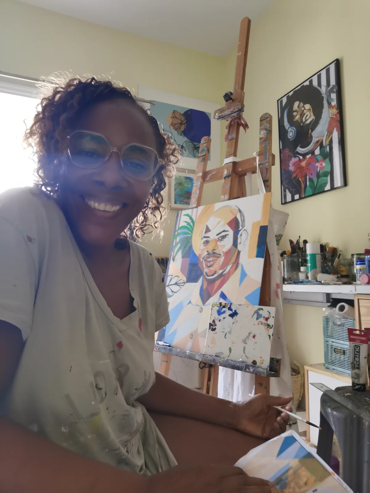 M.A.GIALIART souriante dans son atelier, devant une toile de la série Kaléidoscope